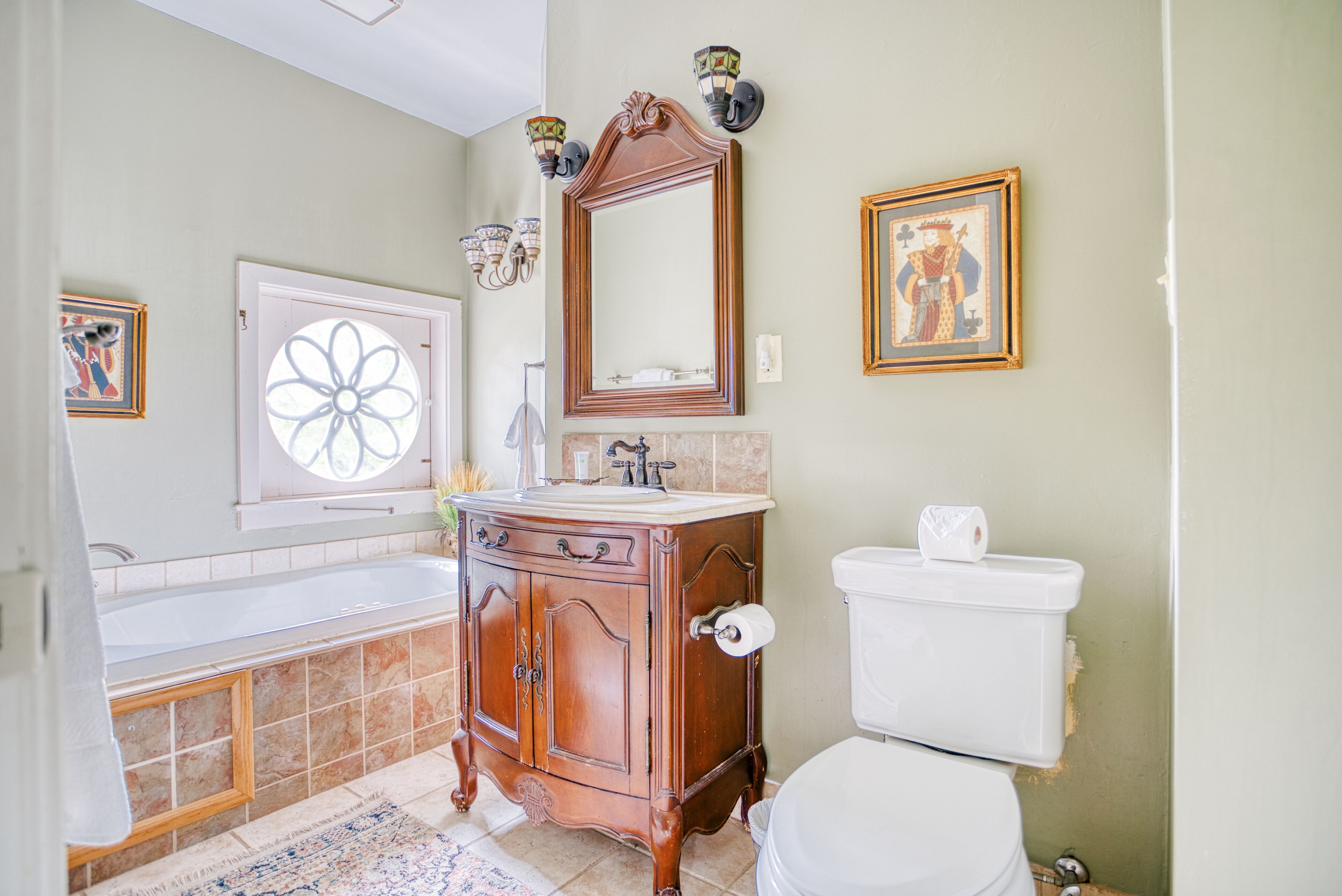 A bathroom with a bathtub, sink, vanity, and toilet.