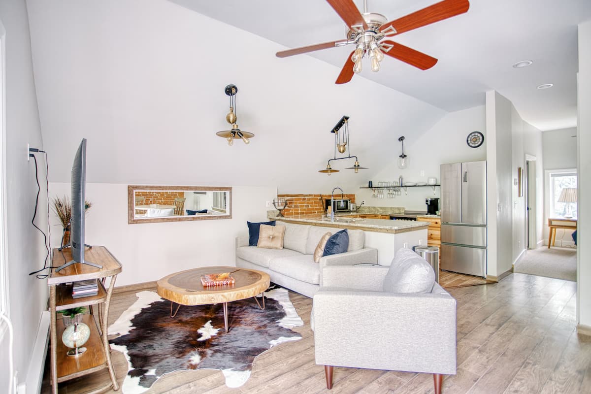 Ein modernes Wohnzimmer mit Sofa, Couchtisch und Deckenventilator.