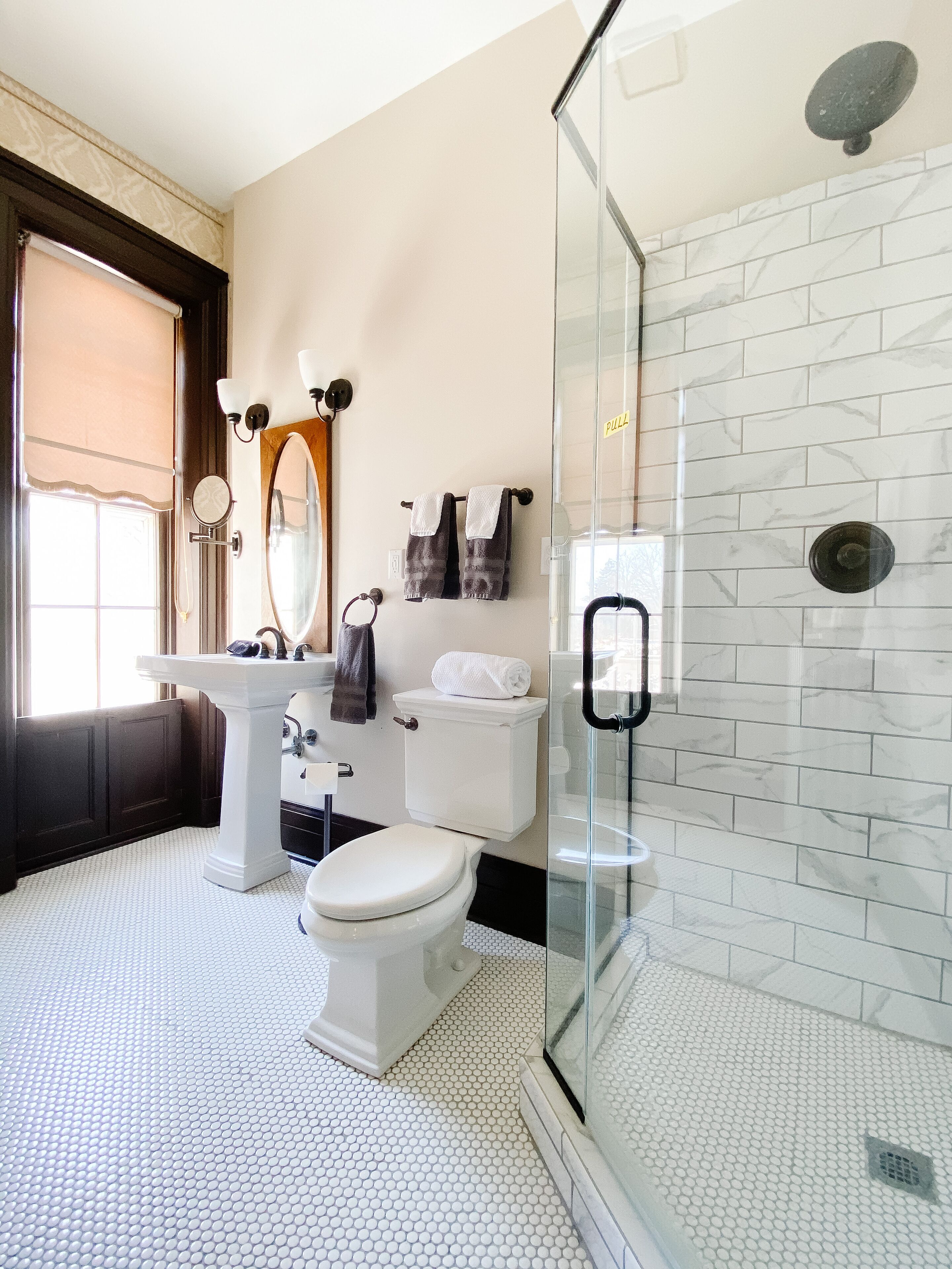 A bathroom with a glass-enclosed shower, a white sink, and a toilet.