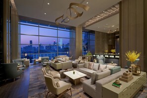 Amplia sala de estar con vista a la ciudad, muebles modernos y un ventanal grande.