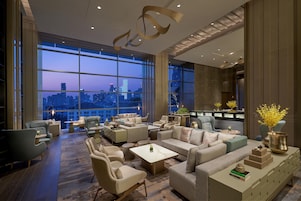Amplia sala de estar con vista a la ciudad, muebles modernos y un ventanal grande.