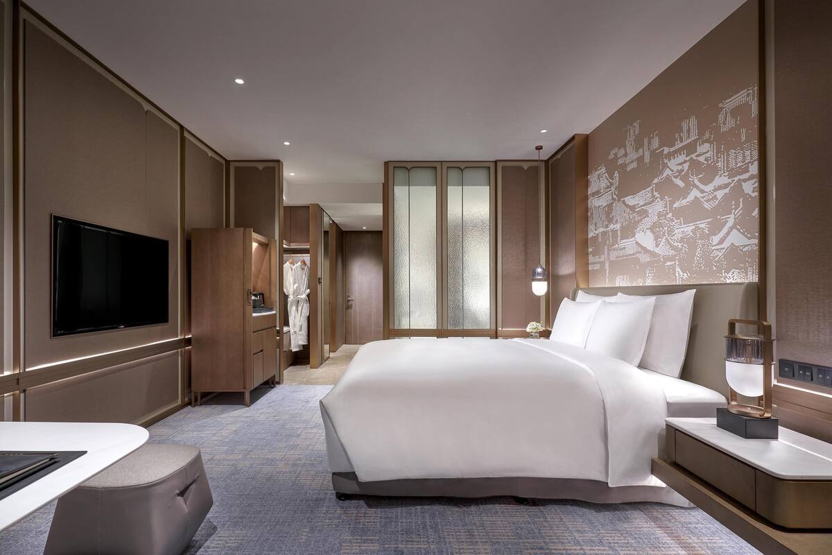 Une chambre d’hôtel dotée d’un grand lit, d’un téléviseur à écran plat, d’un bureau et d’une armoire.