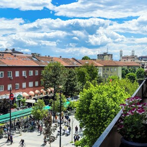 A public square with cafes, a tram, and historic buildings. - Prishtina Center Hostel (Pristina)