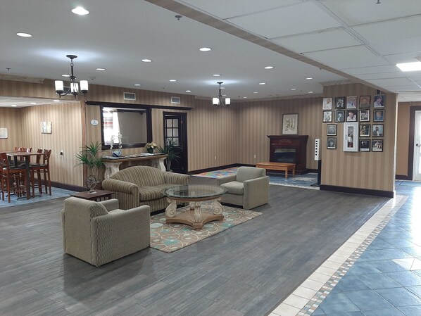 A spacious lobby with a dining area, multiple seating options, and a fireplace.