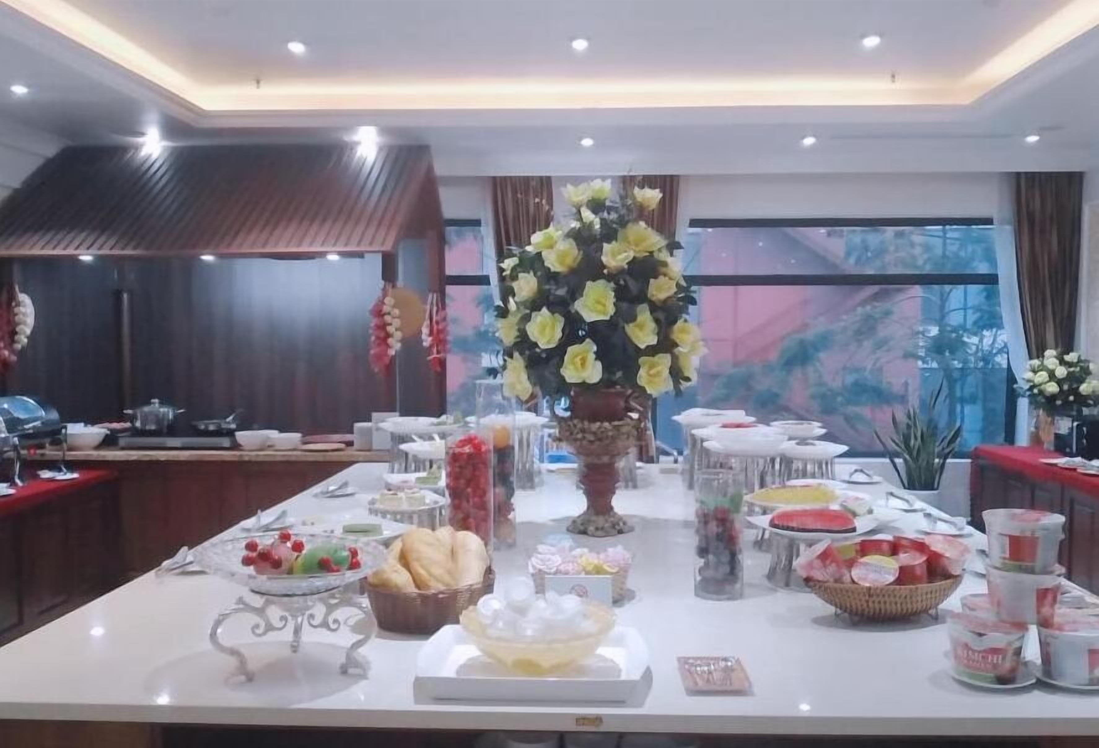 A buffet setup with various food items and a central floral arrangement.