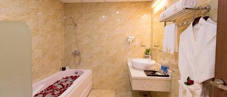 A modern bathroom with a bathtub, shower, and vanity.