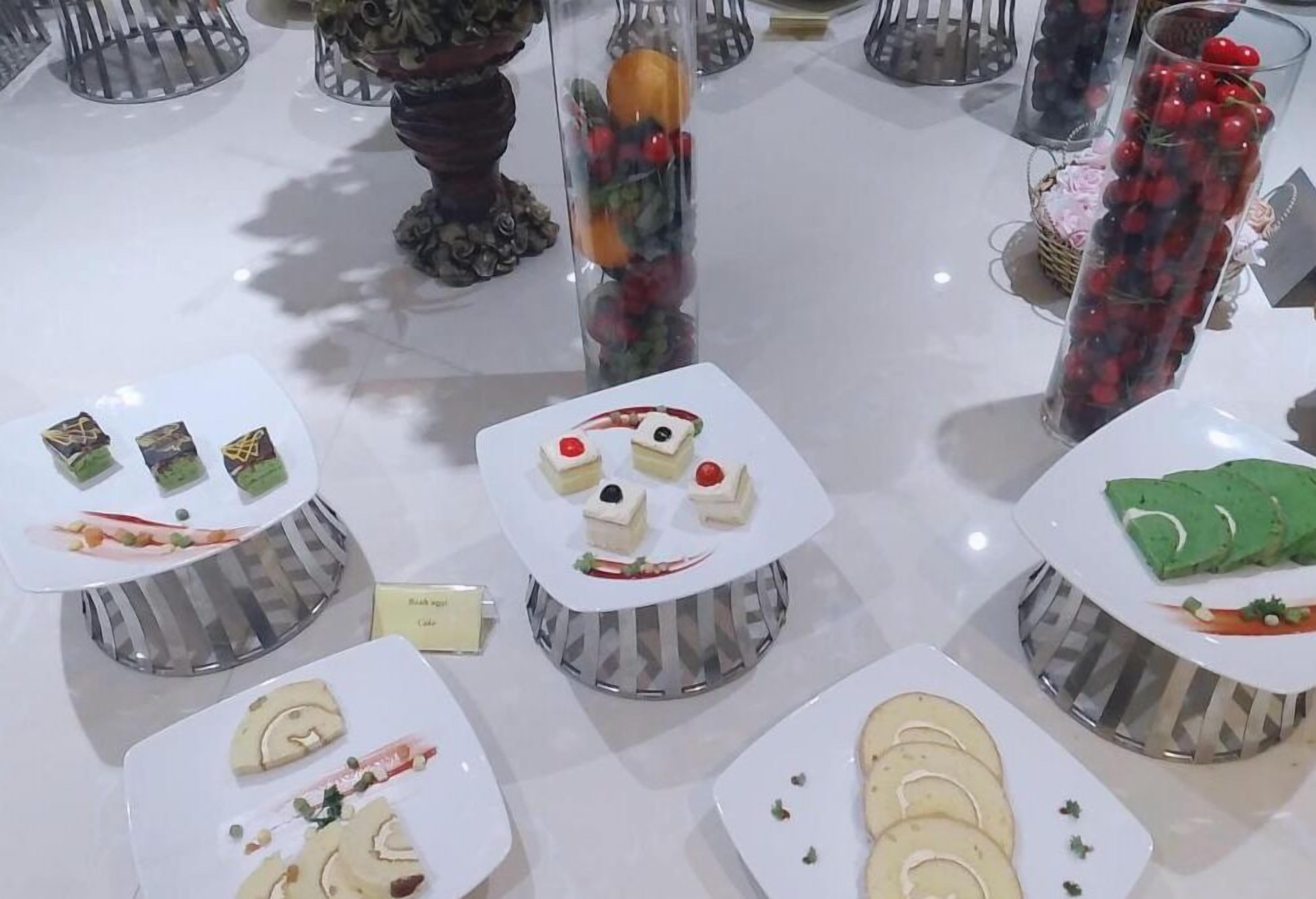 A variety of food items displayed on a table, including pastries, cakes, and fruit.