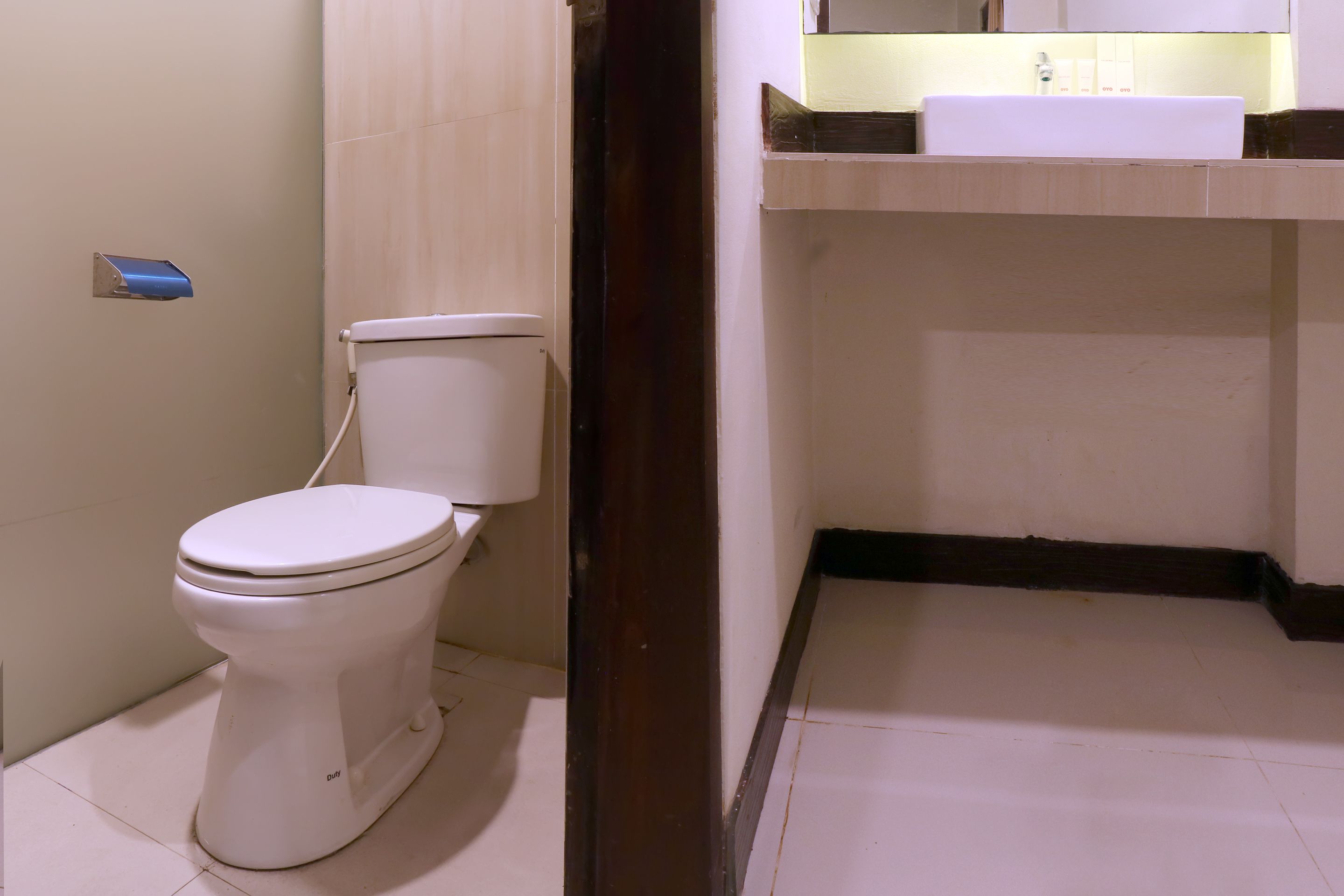 Een badkamer met toilet, wastafel en spiegel.