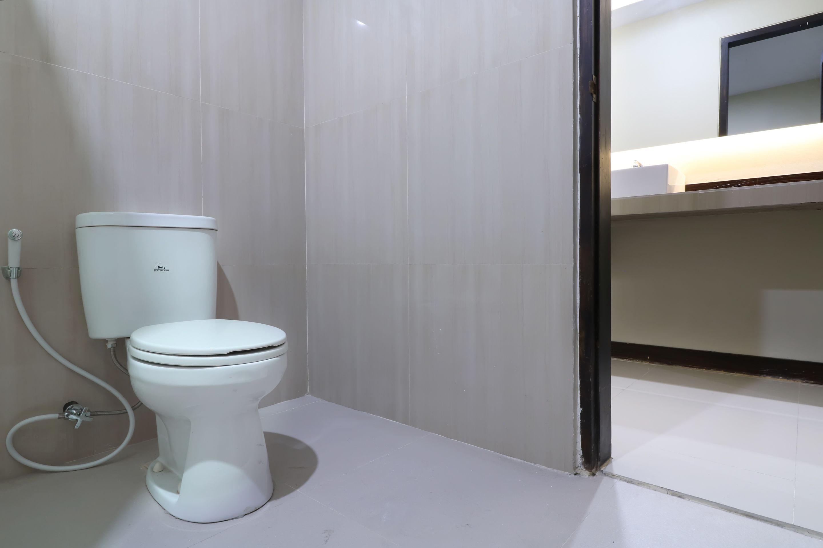 A bathroom with a toilet, a sink, and a mirror.