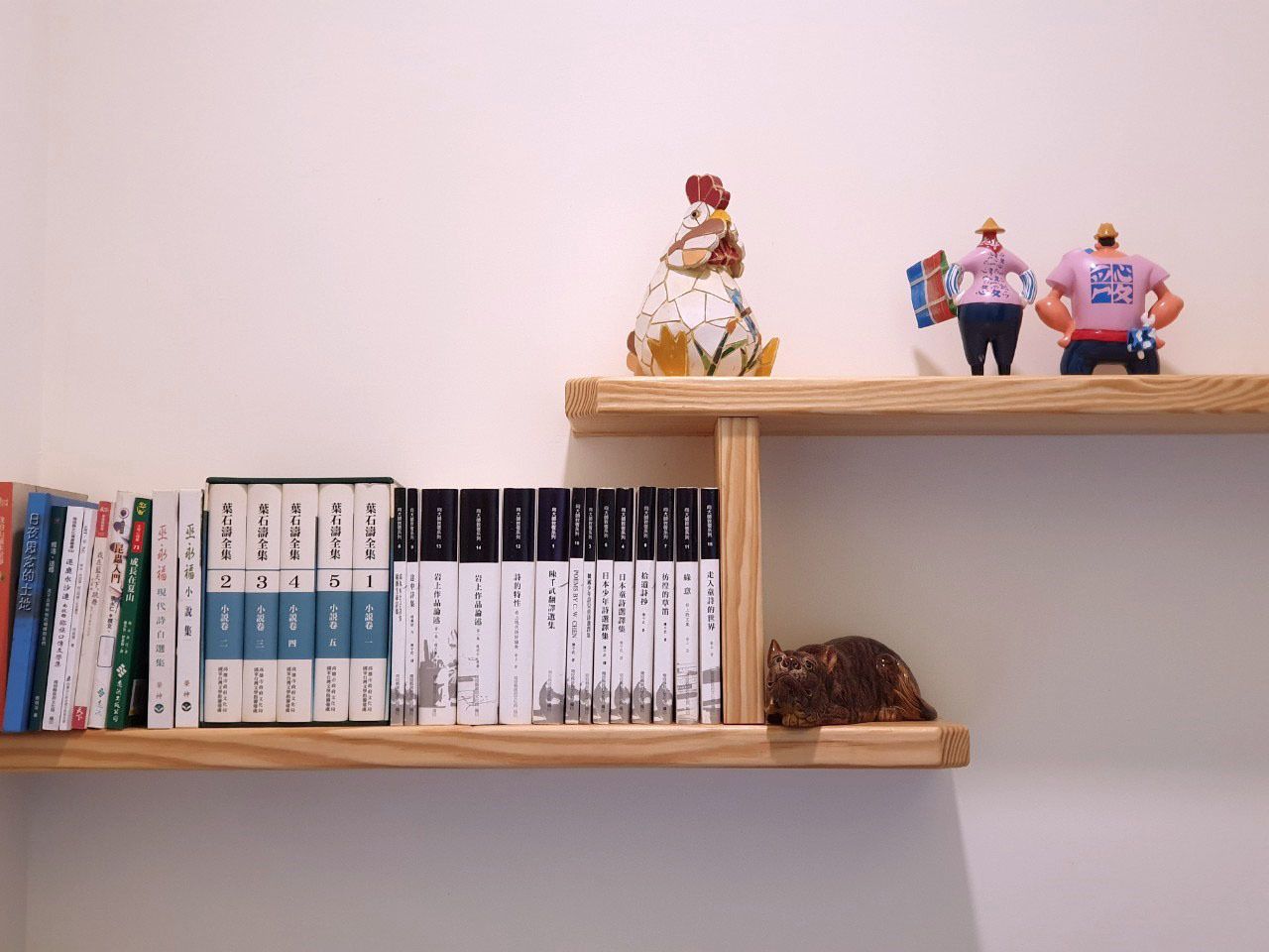 A bookshelf with books and figurines.