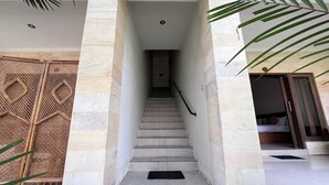 Una escalera con barandilla que lleva a una habitación con cama y ventana.