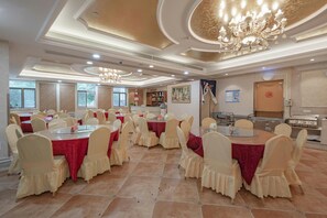 A banquet hall with round tables, chairs, and a chandelier. - Vienna Hotel Shanghai International Tourist Resort Xiuyan Road Metro Station Bra (Shanghai)
