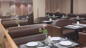A restaurant with booth seating, tables with white tablecloths, and a modern ceiling design. - Vienna Hotel Shanghai International Tourist Resort Xiuyan Road Metro Station Bra (Shanghai)