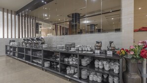 Un espace buffet où les assiettes, les bols et les tasses sont disposés avec soin sur des étagères.