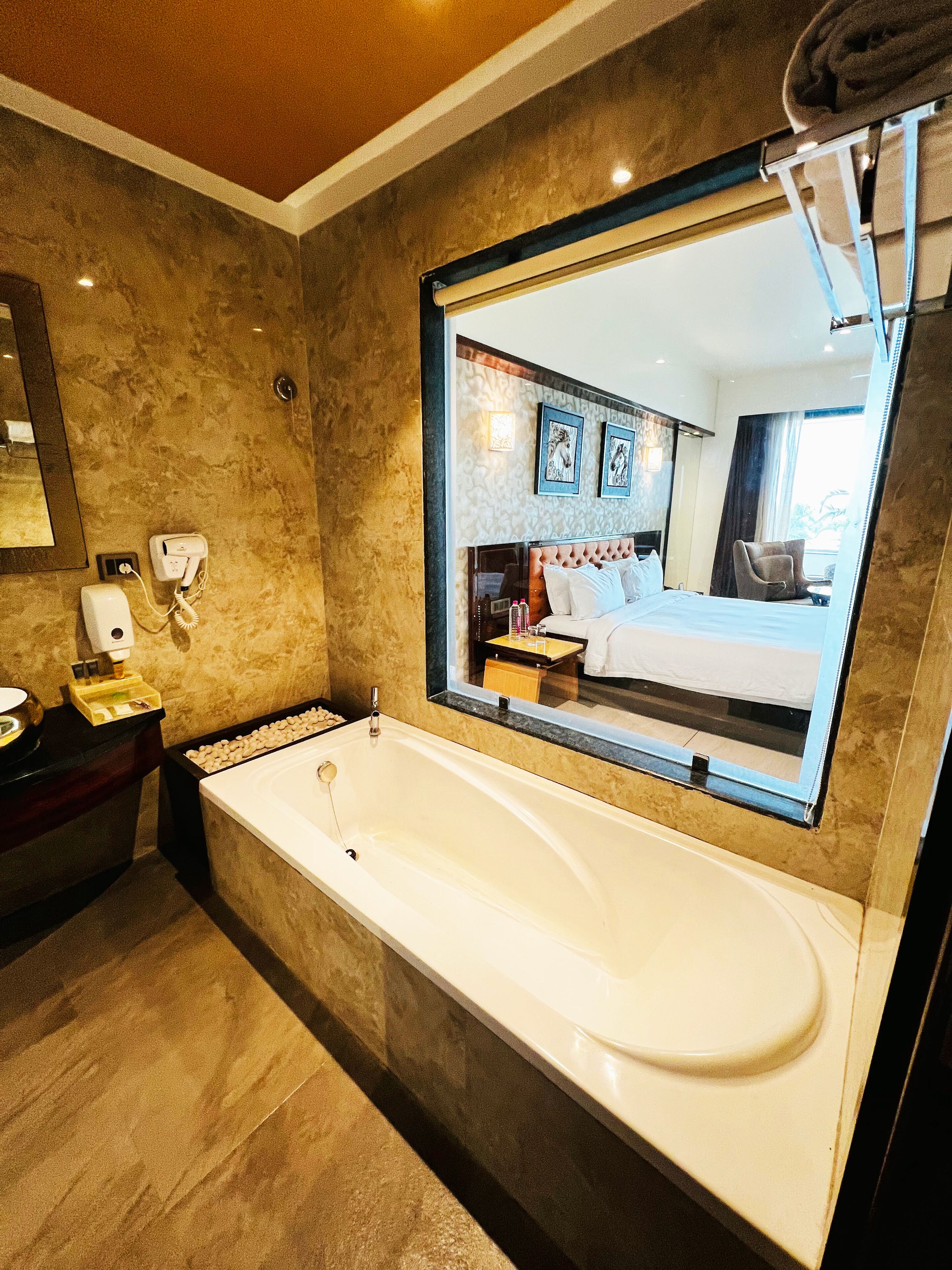 A modern bathroom with a large bathtub, a vanity with a mirror, and a wall-mounted towel rack.