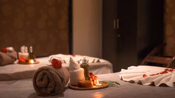 Experience ultimate relaxation in this serene spa room, featuring a massage table, candlelit ambiance, and soothing essentials.