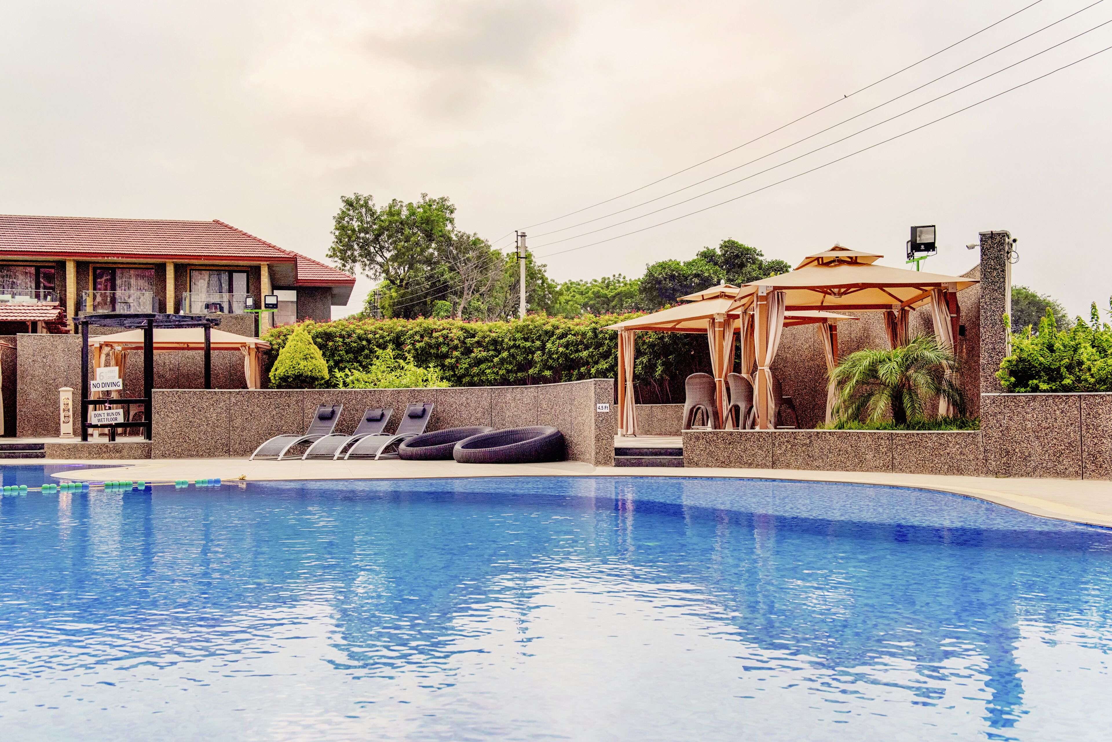 A swimming pool with lounge chairs and a gazebo.