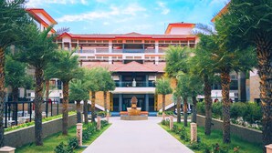 A hotel with a central courtyard, palm trees, and a fountain. - Crescent Spa And Resorts Indore (Indore)