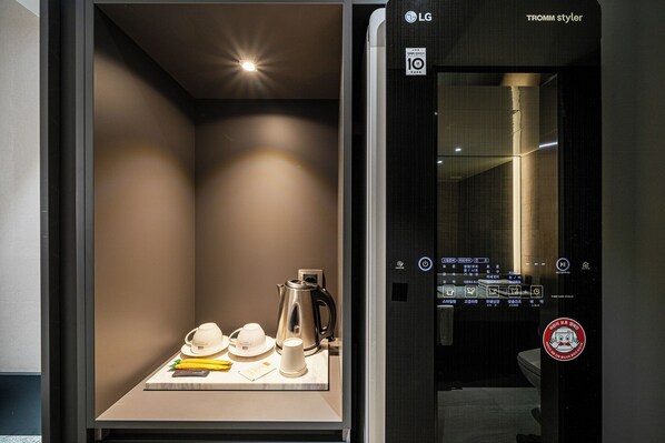 A modern bathroom with a sleek design, a visible control panel, and a towel rack.