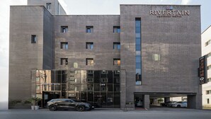 A modern business hotel with a prominent entrance, a cafe, and a parking area. - Rivertain Hotel Gyeongju (Gyeongju)