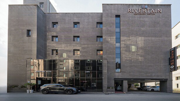 A modern business hotel with a prominent entrance, a cafe, and a parking area. - Rivertain Hotel Gyeongju (Gyeongju)