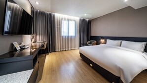 A modern hotel room with a large bed, a desk with a telephone, a chair, and a large mirror. - Rivertain Hotel Gyeongju (Gyeongju)