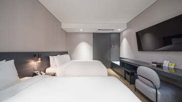 A modern hotel room with a large bed, a desk, and a flat-screen TV.