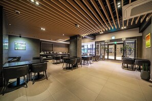 A modern restaurant with a wooden ceiling, black tables, and chairs. - Rivertain Hotel Gyeongju (Gyeongju)