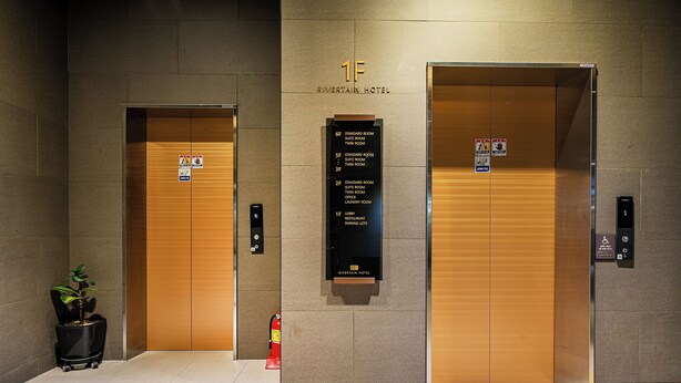 Two elevator doors with a sign above indicating the 1F level of Riverview Hotel, including standard and twin room options. - Rivertain Hotel Gyeongju (Gyeongju)