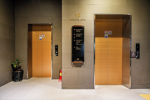 Two elevator doors with a sign above indicating the 1F level of Riverview Hotel, including standard and twin room options. - Rivertain Hotel Gyeongju (Gyeongju)
