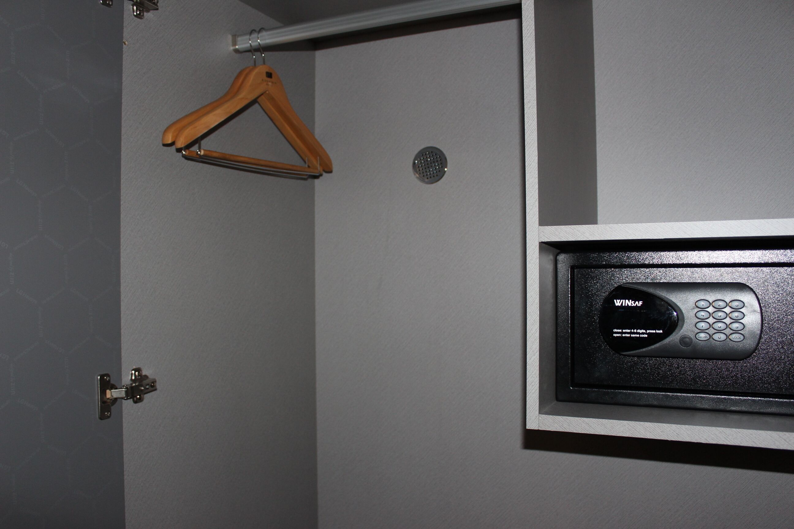 A bathroom with a towel rack, a shower control panel, and a door.