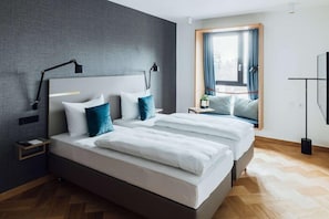 A modern hotel room with a large bed, two bedside tables, a nightstand, a window with curtains, and a view of the outdoors. - Vienna House Kronberg (Kronberg)
