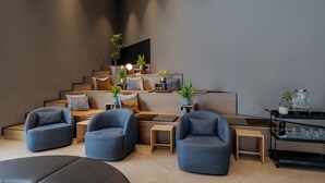 Un salon moderne doté d’un escalier, d’un coin salon et d’un espace dédié à la préparation du café.
