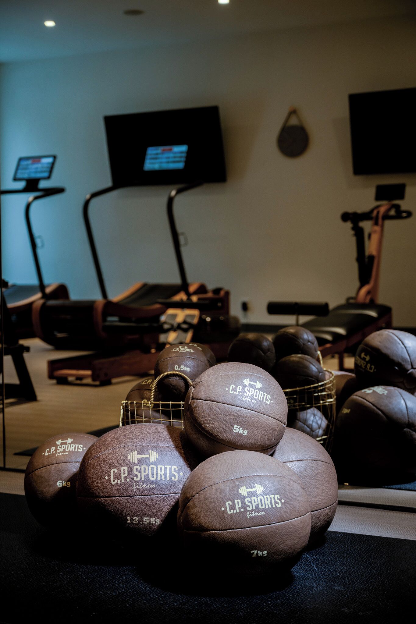 Une salle de sport équipée de matériel d’exercice et dotée d’un téléviseur fixé au mur.