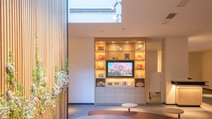 A modern interior with a wooden wall, a round table, and a seating area. - Hotel Keihan Kyotoeki Minami (Kyoto)