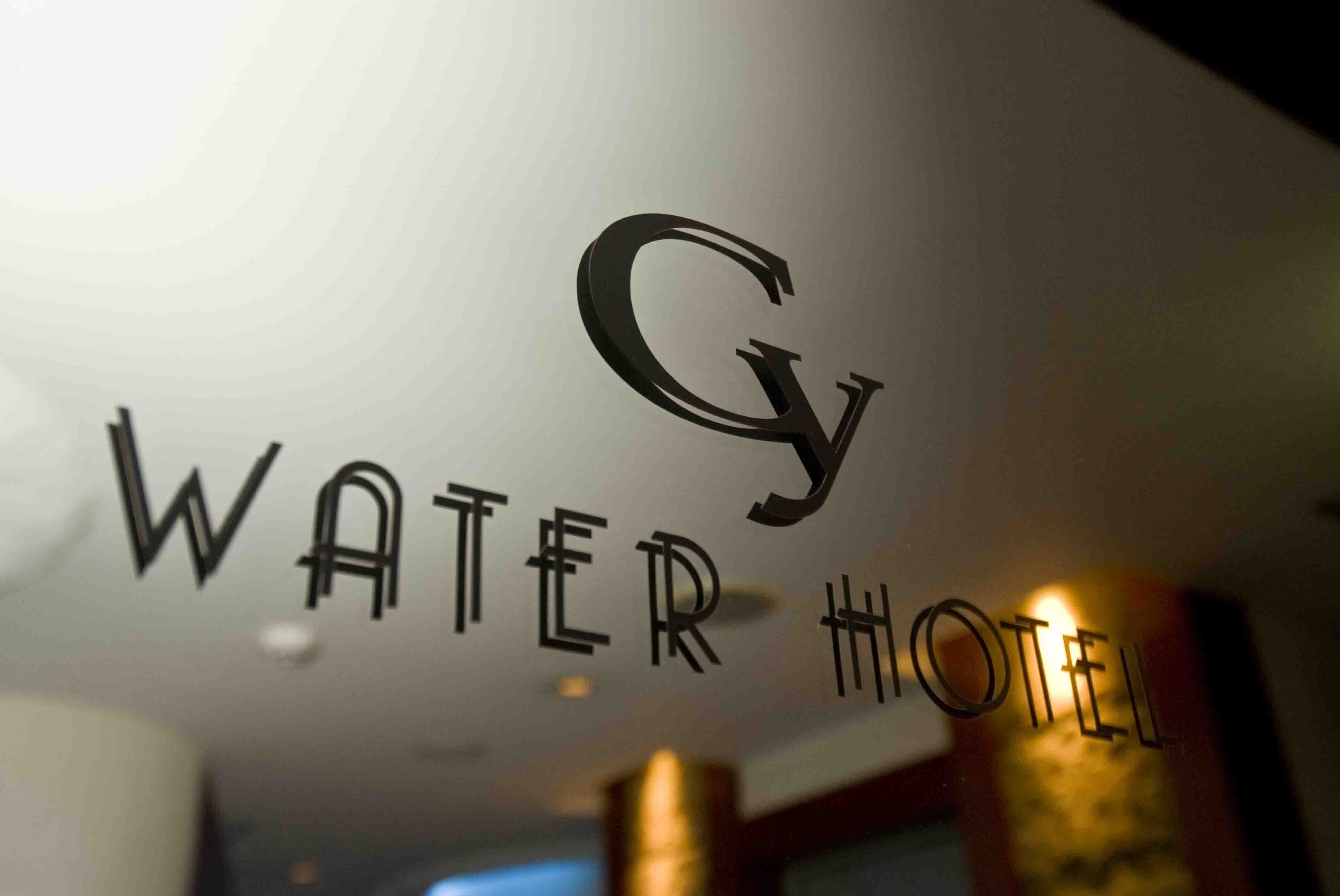 A sign with the text "WATER HOTEL" and a stylized 'G' logo.