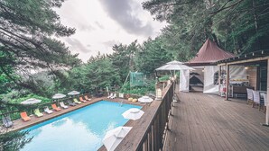 A wooden deck with a pool, lounge chairs, and a gazebo. - Couplestar in Forest Glamping (Hoengseong)