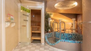 A sauna area with wooden benches and a tiled floor. - Walter's Gästehaus (Assling)