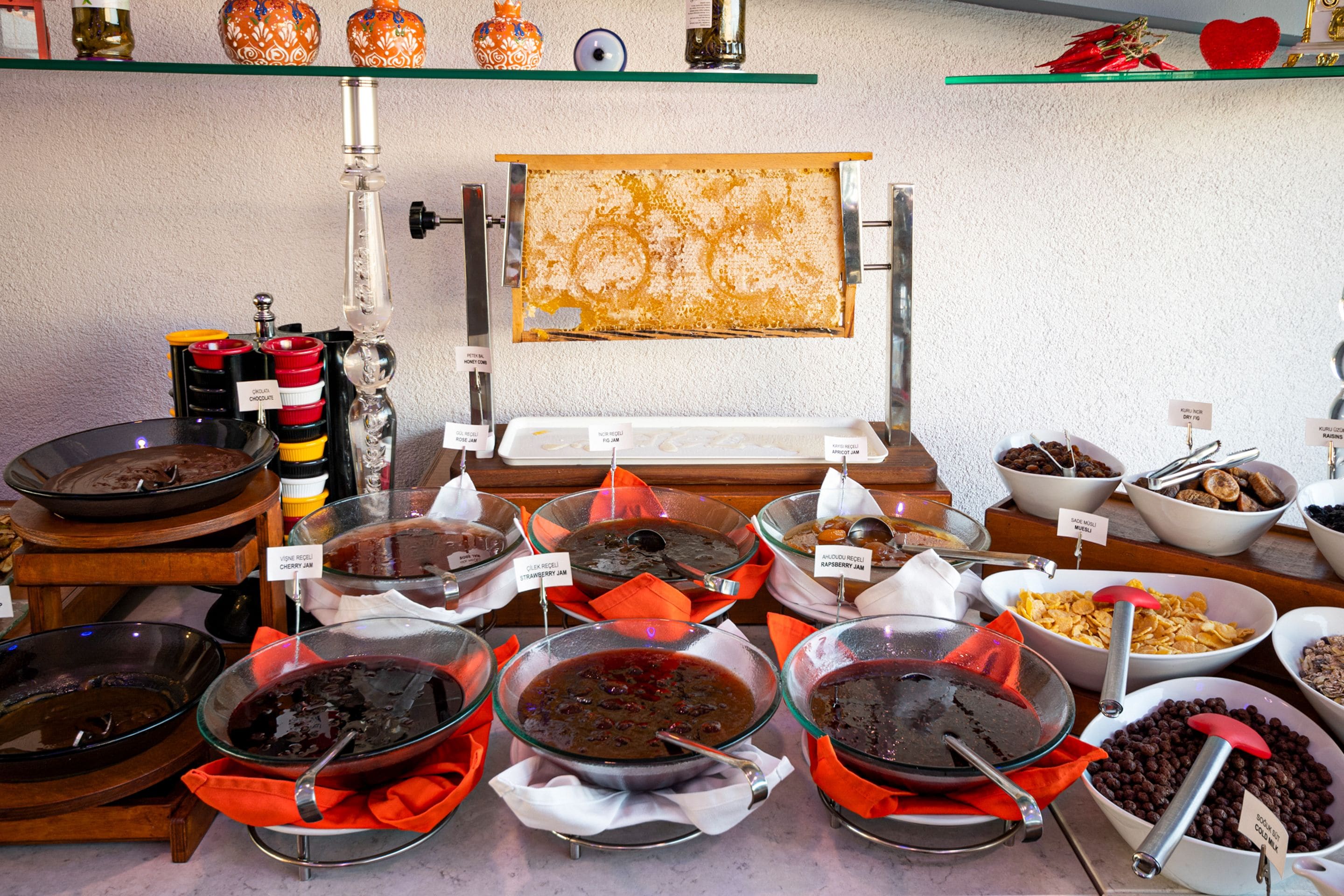 A buffet with various food items and a large decorative piece on the wall.