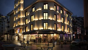 Un hotel amb un restaurant terrassa, nombroses galeries i una façana ben il·luminada.