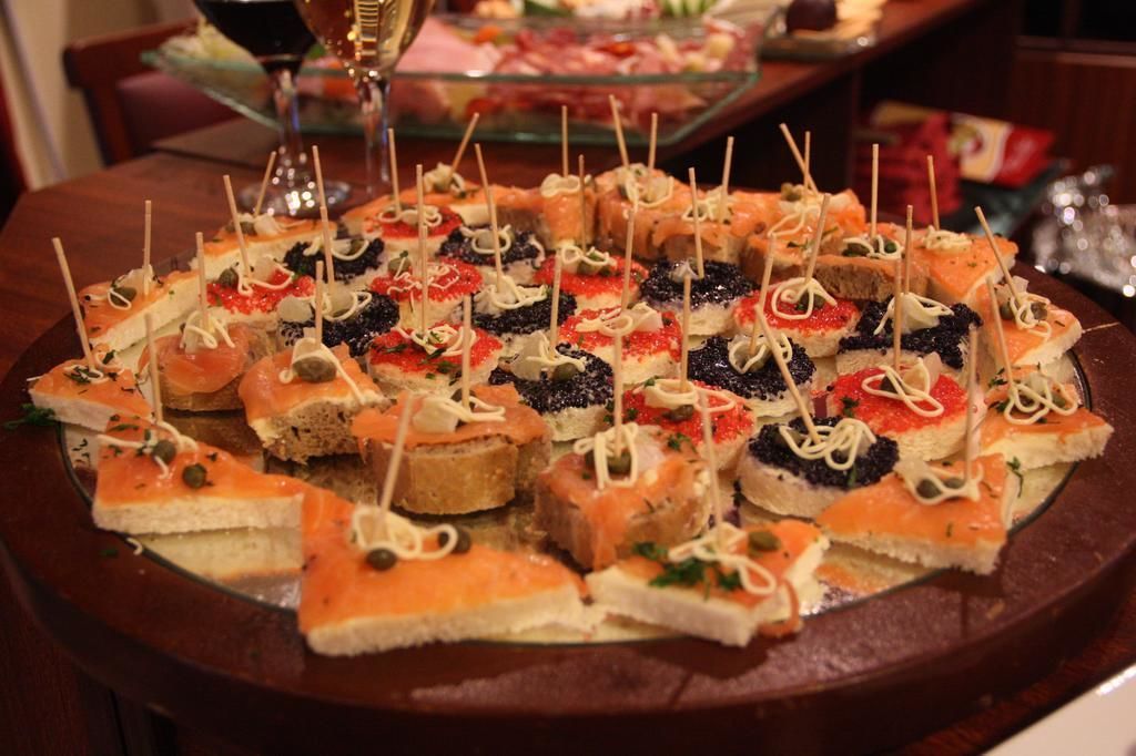 A variety of appetizers arranged on a round table, including items with toothpicks.