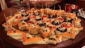 A variety of appetizers arranged on a round table, including items with toothpicks.