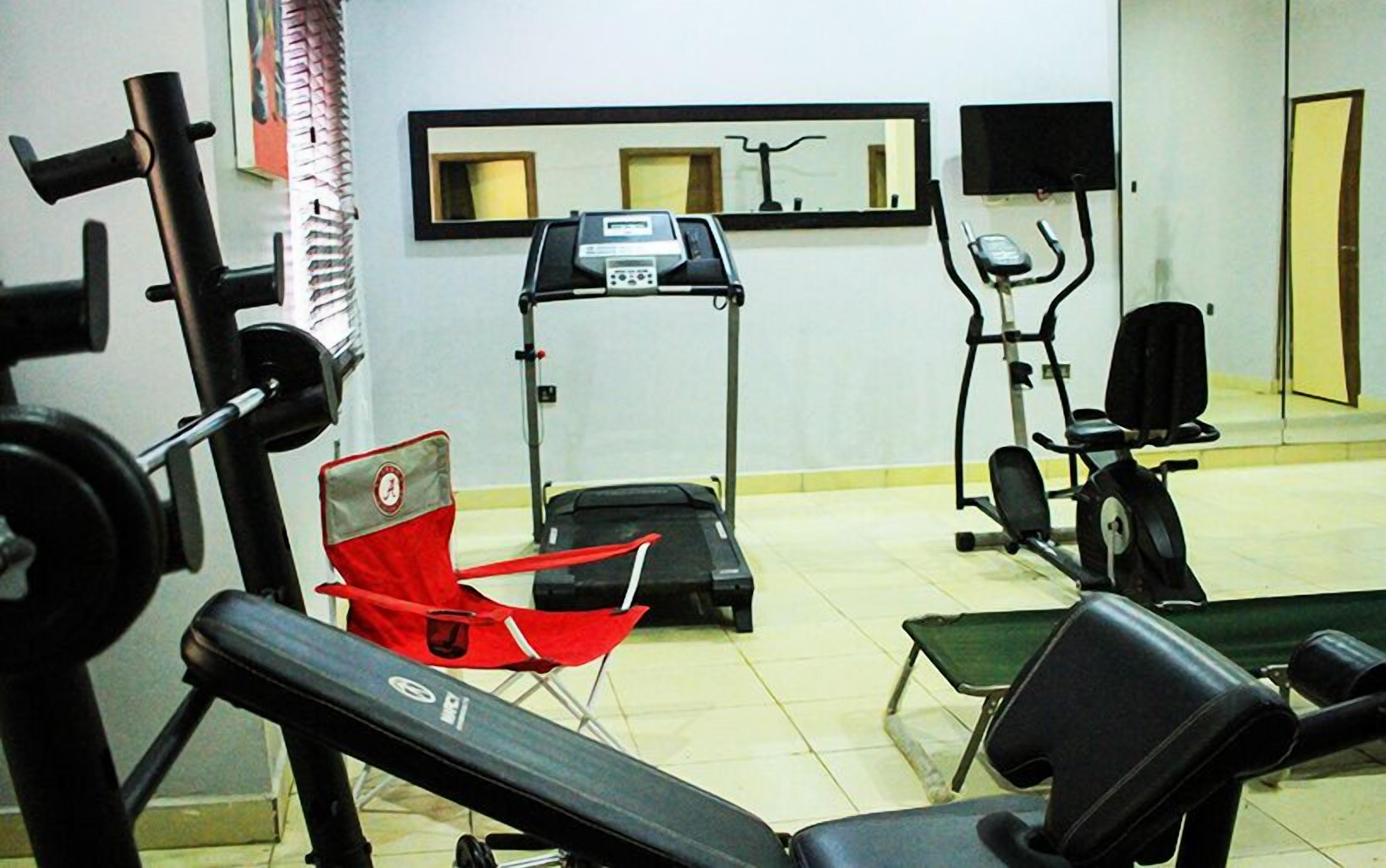 A gym with exercise equipment, including a treadmill, stationary bike, and weight machines.