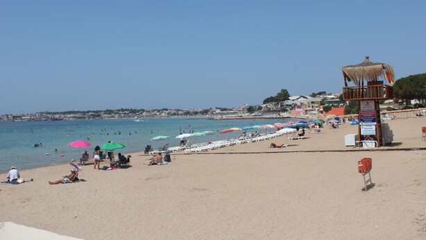A beach with umbrellas, chairs, and a lifeguard tower. - Tasan Apart Otel (Didim)