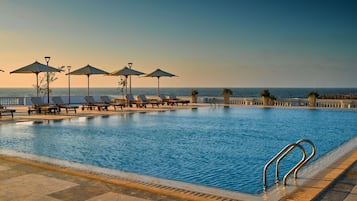 Piscine extérieure, parasols de plage, chaises longues