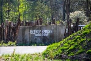 A sign for Beekse Bergen Safari Resort with a rustic wooden fence and greenery in the background. - Safari Resort Beekse Bergen (Hilvarenbeek)