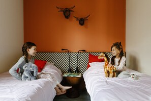 A room with two beds, a wooden headboard, a red pillow, and a magazine on the nightstand. - Safari Resort Beekse Bergen (Hilvarenbeek)