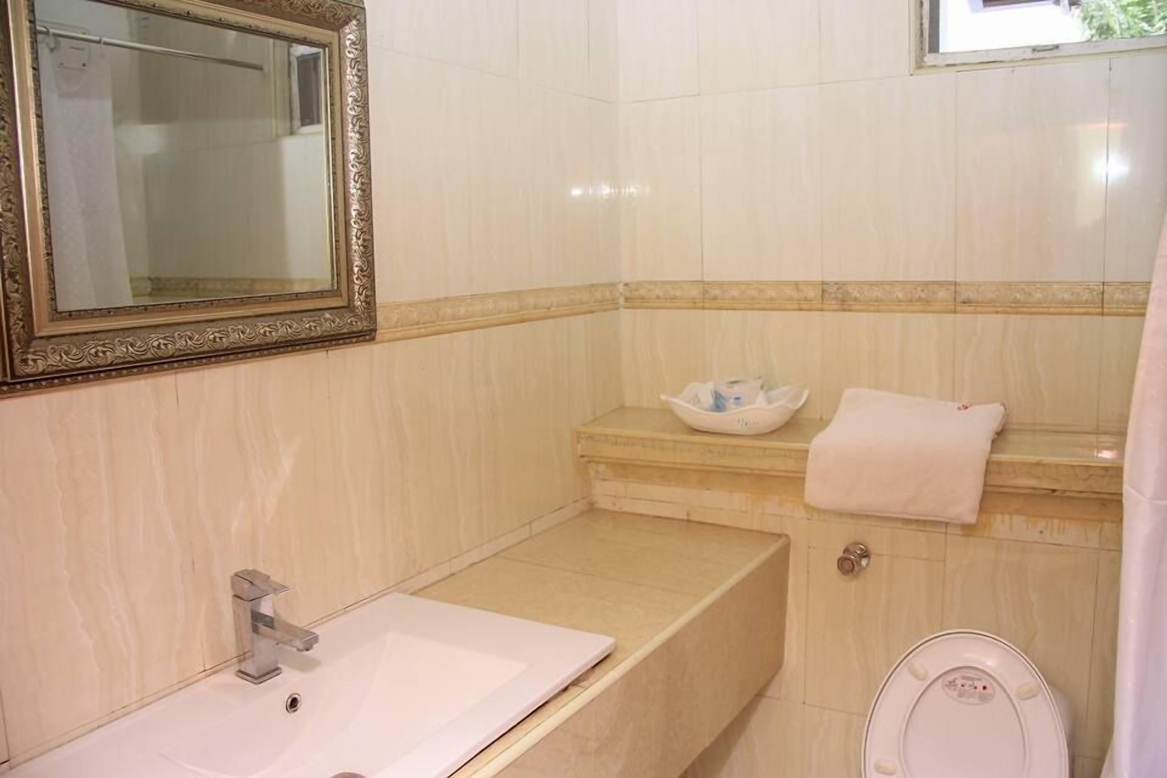 A bathroom with a sink, mirror, bathtub, and toilet.