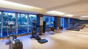 A gym with treadmills, ellipticals, and a rowing machine. - Wingtech Hotel (Huangshi)