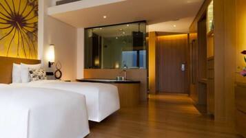 Une chambre d’hôtel avec deux lits, un grand miroir, un lavabo et un plancher en bois.
